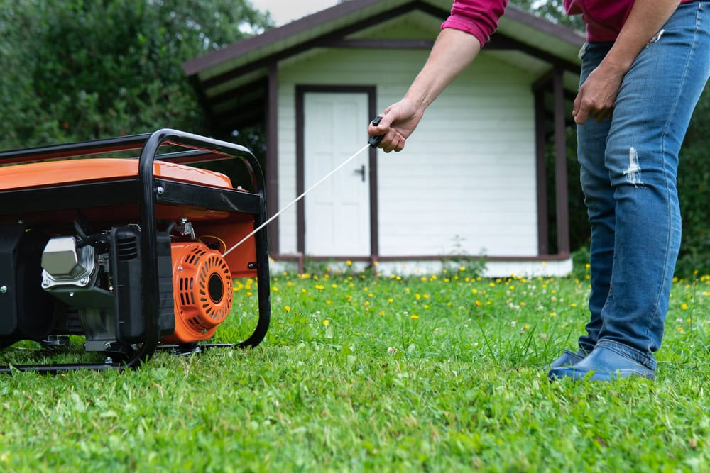 A low angle of a man's legs and arms as he pulls a cable that turns on electric generators