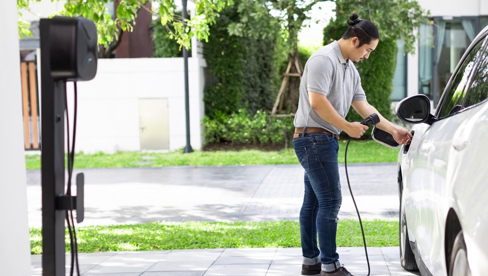 a man charging his electric car after an EV Charger Installation